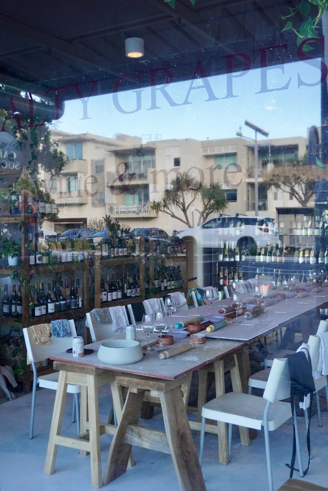 Guests at the long table through the Salty Grapes window